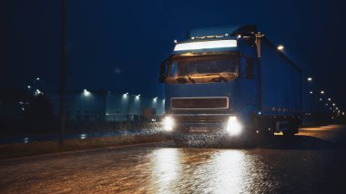 Blue Long Haul Yarı-Kamyon Kargo Karavanıyla Gece Yolculuğu Otoyol 'da, Kıta boyunca Yağmur, Sis ve Karla. Endüstriyel Depo Bölgesi.
