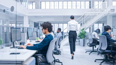 Güzel Bayan Yönetici İş Meslektaşları Geçidi 'nden geçiyor. Modern Açık Ofiste Çeşitli ve Motivasyonlu İş Adamları Bilgisayarlar Üzerinde Çalışıyor.