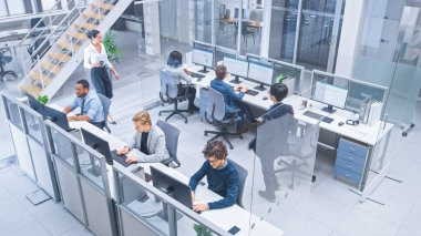 Çeşitli İşletme Yöneticileri ve Uzmanlar Ekibi Masaüstü Bilgisayarları üzerinde Çalışıyor, Meslektaşlarıyla Tartışıyor. Modern Açık Ofiste Genç ve Motivasyonlu İş İnsanları. Yukarıdan çekilen.