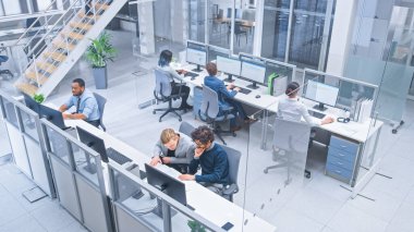 Çeşitli İşletme Yöneticileri ve Uzmanlar Ekibi Masaüstü Bilgisayarları üzerinde Çalışıyor, Meslektaşlarıyla Tartışıyor. Modern Açık Ofiste Genç ve Motivasyonlu İş İnsanları. Yukarıdan çekilen.