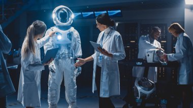 Beyaz Önlük Giyen Çeşitli Uzay Bilimcileri ve Mühendisleri Ekibi Galaksi Keşfi ve Seyahati İçin Yeni Uzay Giysileri Tasarladı, Kullandı. Astronot Kıyafeti Yapılıyor
