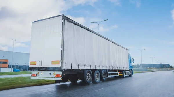 Lang-Lkw mit Lastanhänger voller Güter unterwegs auf der Autobahn. Tagsüber über den Kontinent durch Regen, Nebel. Bereich Industriehallen. — Stockfoto