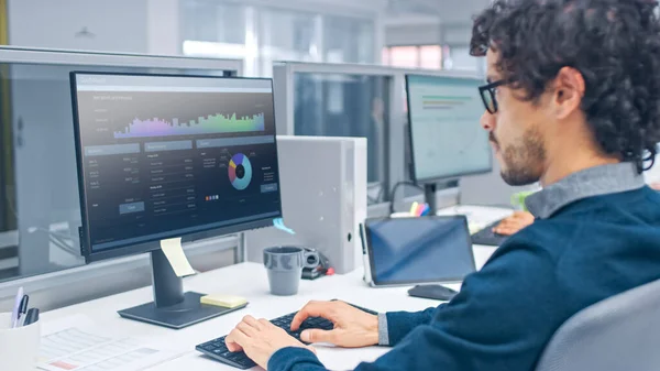 Young Handsome Manager with Curly Hair Works on a Desktop Computer in Accountant Software. Diverse and Motivated Business People Work on Computers in Modern Open Office. — Stock Photo, Image