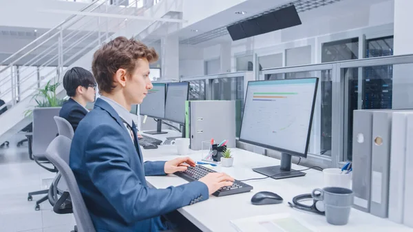 젊은 Handsome Manager Wearing a Suit 와 Tie 는 자신의 책상 뒤에서 일하고 있다. Diverse and Motivated Business People Work on Computers in Modern Open Office. — 스톡 사진