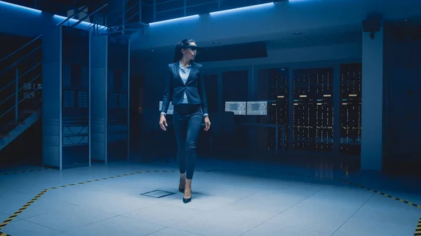 In 3D Content Creating Laboratory Stylish and Beautiful Female Engineer Wearing Professional Virtual Reality Headset Works and Gestures in Augmented Reality, Walking Through Facility