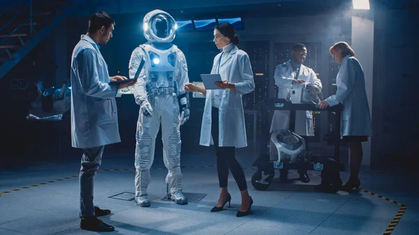 Uzay Mühendisleri Ekibi Galaksi Keşfi ve Seyahat İçin Yeni Uzay Giysileri Tasarladı. Beyaz önlük giyen bir grup bilim adamı tartışır, bilgisayar kullanır. Astronot Miğferi Yapılıyor — Stok fotoğraf