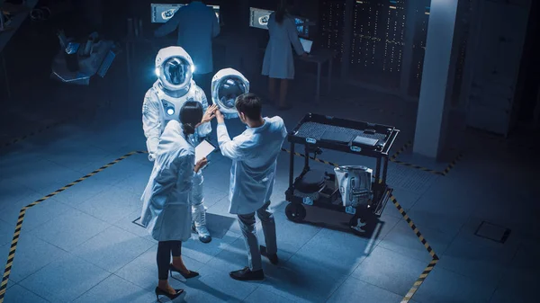 Aerospace Facility: Scientists, Engineers Wearing White Coats have Discussion, Use Computers, Construct Astronaut Helmet for New Space Suit Adapted for Exploration and Travel. Elevated High Angle Shot — Stock Photo, Image