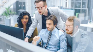 Modern Ofis 'te: Çeşitli İş Adamları ve İş Kadını Ekibi Bilgisayar üzerinde Çalışıyor, Tartışıyor, Sorunlu Çözüm Bulmaya Çalışıyor. Genç ve Motivasyonlu İş İnsanları Konuş ve Planla