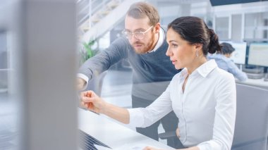 Güzel İş Kadını Masaüstü Bilgisayarı Kullanıyor, Proje Yöneticisine Grafik ve İstatistiklerle Belgeler Hakkında Danışmanlık Yapıyor. Arka planda takım çalışması. Büyük Şirket Ofisi.