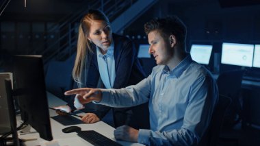 Hırslı ve kendinden emin işadamı, Masaüstü Bilgisayarı kullanıyor, Kadın Proje Yöneticisi, Özel Görevleri, Hesapları, Stratejik Hareketleri Açıklıyor. Profesyonel İnsanlar Şirket Ofisinde Gece Geç Saatlere Kadar Çalışıyor