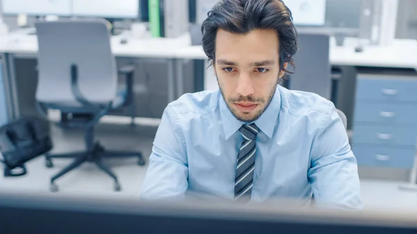 Handsome Motivated Office Worker 는 데스크톱 컴퓨터를 사용하여 키 보드에 타이핑 한다. 신임받는 젊은 사업가와 전문가 팀과 함께 빅 브라이트 사무실에서 일하다 — 스톡 사진