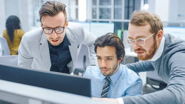 In Bright Modern Office: Businessman Setting and Working at His Desktop Computer, Project Manager and Team Leader Standing Beside. 그들은 토론을 하고, 문제 해결을 찾으며 , 스크린 에서 그림을 그리고 있다 — 스톡 사진