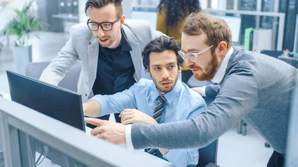 In Bright Modern Office: Businessman Setting and Working at His Desktop Computer, Project Manager and Team Leader Standing Beside. 그들은 토론을 하고, 문제 해결을 찾으며 , 스크린 에서 그림을 그리고 있다 — 스톡 사진