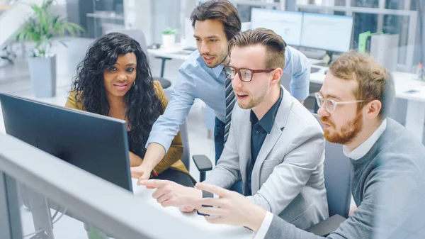 Im modernen Büro: Vielfältiges Team aus Geschäftsleuten und Unternehmerinnen arbeitet am Computer, diskutiert, findet erfolgreich Probleme, applaudiert und feiert fröhlich. Glückliche und motivierte Geschäftsleute — Stockfoto