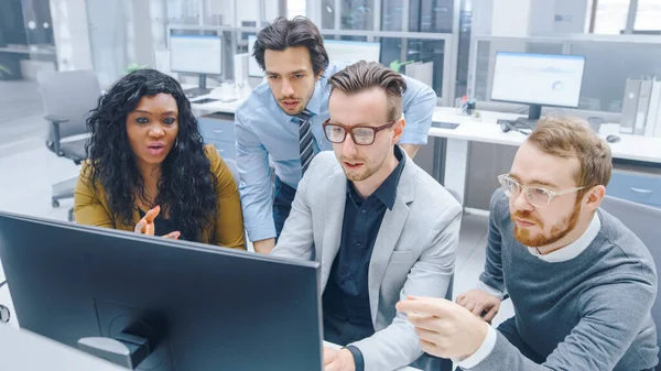 Dans le bureau moderne : Une équipe diversifiée de jeunes hommes d'affaires motivés et femmes d'affaires travaillent sur ordinateur, discutent, trouvent collectivement une solution aux problèmes. Collaboration ambitieuse des gens d'affaires — Photo