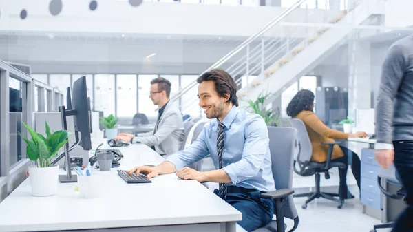 Retrato de bonito e confiante camisa e gravata vestindo empresário usa computador desktop, digitando em um teclado, monitorando transações comerciais, assinando contratos. Trabalha no Big Bright Office — Fotografia de Stock