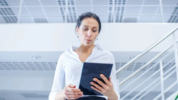 Dans le bureau d'entreprise lumineux : Femme exécutif tenant tablette numérique marche à travers le bureau où son personnel professionnel des gens d'affaires travaillent sur les ordinateurs de bureau — Photo