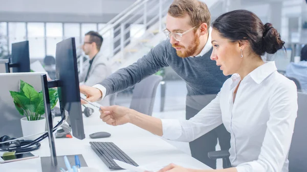 Schöne Geschäftsfrau verwendet Desktop-Computer, berät ihren Projektleiter über Dokumente mit Grafiken und Statistiken. Im Hintergrund Großunternehmen — Stockfoto