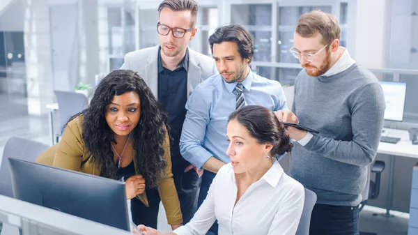 I Modern Office: Diverse Team of Young Motivated Businessmen and Businesswoman Work on Computer, having discussion, Finding Problem Solution Collective (engelsk). Ambisiøse forretningsfolk Suksessfullt teamarbeid – stockfoto