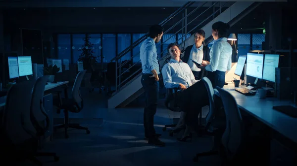 Sent på Night in Modern Office: Diverse Team of Successful and Ambious Businessmen and Businesswomen Work on Computer, Having Discussion, Finding Problem Solution, Finishing Project Together. – stockfoto