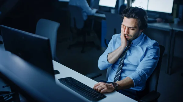 Im nächtlichen Büro gähnt ein übermüdeter Büroangestellter. Müder erschöpfter Geschäftsmann beendet wichtiges Projekt — Stockfoto