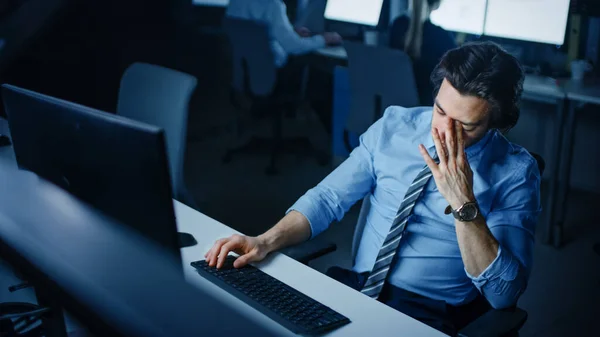 In het kantoor 's nachts overwerkt Vermoeide Kantoormedewerker maakt gebruik van Desktop Computer Yawning. Moe Uitgeputte Zakenman Afwerking Belangrijk Project — Stockfoto