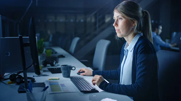 オフィスで夜遅くまで作業する:デスクトップコンピュータを使用してビジネス女性,分析,ドキュメントを使用して,問題を解決,プロジェクトを終了. — ストック写真
