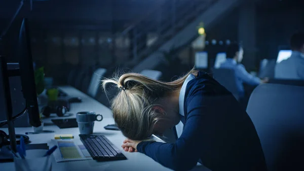 夜のオフィスで過労した女性のオフィスワーカーは彼女の手に眠りに落ちました.彼女はデスクトップコンピュータを使用しています。疲れている排気事業の女性重要なプロジェクトを終了 — ストック写真