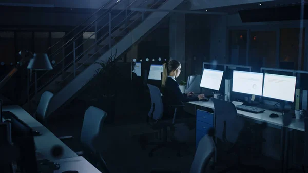 Trabajando tarde en la noche en la oficina: Empresaria que usa computadora de escritorio, analizando, usando documentos, resolviendo problemas, terminando el proyecto. — Foto de Stock