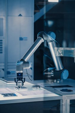 Gelecekteki Yapay Zeka Robot Kolunun Dikey Çekimi Bir Metal Nesneyi Çalıştırır ve Taşır, Kaldırır ve Yere Koyar. Sahne Modern Ekipmanlarla Yüksek Teknoloji Araştırma Laboratuvarında Çekildi