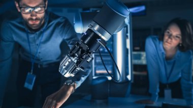 Fütürist Robotik Kol Kapanışı Metal Bir Nesneyi Kaldırıp Taşımak. Bu Gelişmiş Süreç 'i takip eden Mühendisler Takımı. Modern ekipmanlarla Yüksek Teknoloji Araştırma Laboratuvarındalar..