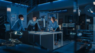 Gelecekçi Metal Robotik Kol Metal Cismi Taşıyor. Kıdemli Mühendis, bu Gelişmiş Süreci Çeşitli Ekibiyle Görüşüyor. Modern ekipmanlarla Yüksek Teknoloji Araştırma Laboratuvarındalar..