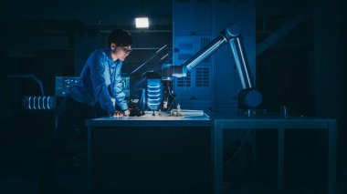 Japon Geliştirme Mühendisi Yapay Zeka Arayüzü 'nü Fütürist Robot Kolu ile Satranç oynayarak test ediyor. Low Key Light ile birlikte yüksek teknoloji modern araştırma laboratuvarındalar..