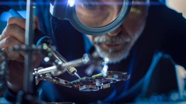 Elektronik Bakım ve Onarım Mühendisi Lehim Ana Kart, Mikroçip ve Devre Panosu Büyüteç 'ten bakıyor. Kavramsal Çekim: Düşük Açı Büyütme Gözü ve Yüzü