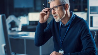 Şahsi Bilgisayarda Gözlük Giyen Orta Çağlı Mühendis Portresi. Arka plan Yüksek Teknoloji Mühendislik Tesisinde.