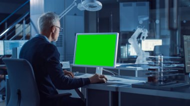 Profesyonel Ağır Sanayi Mühendisi Green Mock-up Bilgisayar 'da çalışıyor. Çeşitli Robot, Mimari ve Makine Bileşenlerine sahip Mühendislik Bürosu ve Endüstriyel Tasarım Ajansı