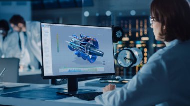 Omuz Fotoğrafı: Kadın bilişim bilimcisi CAD yazılımını uçak motoru ile gösteren bir bilgisayar kullanıyor. Bilim adamları ve Mühendislerle Arka plan Teknoloji Geliştirme Laboratuvarında