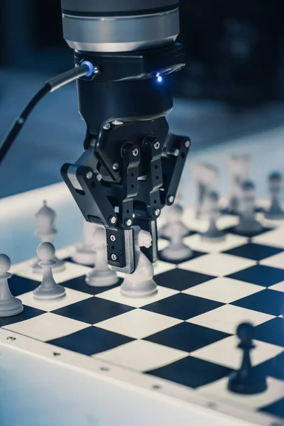 Close Up Vertical Shot of Artificial Intelligence Operating a Futuristic Robotic Arm in a Game of Chess. Robot Moves a Knight. High Tech Modern Research Laboratory.