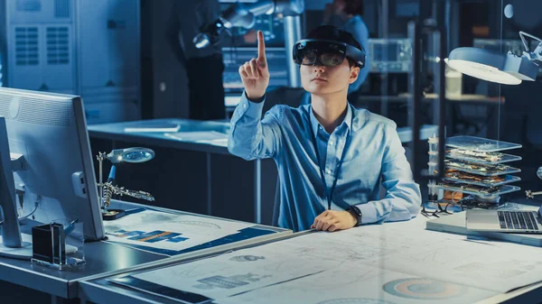 Professional Japanese Development Engineer travaille dans un casque AR, faisant des gestes de déplacement de pièces graphiques virtuelles autour dans le laboratoire de recherche de haute technologie avec du matériel informatique moderne. — Photo