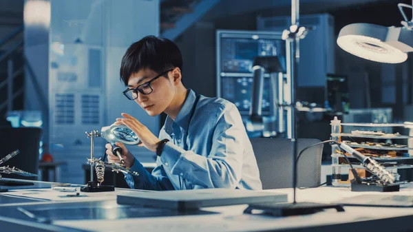 Engenheiro de Desenvolvimento Eletrônico Japonês Profissional em Camisa Azul está Soldando uma Placa de Circuito em um Laboratório de Pesquisa de Alta Tecnologia com Equipamento de Computador Moderno. — Fotografia de Stock