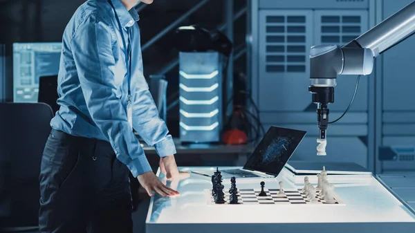 Ingeniero de Desarrollo Japonés Profesional está Probando una Interfaz de Inteligencia Artificial Jugando Ajedrez con un Brazo Robótico Futurista. Están en un Laboratorio de Investigación Moderna de Alta Tecnología. —  Fotos de Stock