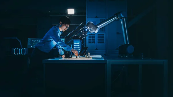 일본 개발 엔지니어는 인텔리전트 인터페이스 (Artificial Intelligence Interface) 를 미래 지향적 로봇 팔로 체스 (Chess with a Futuristic Robotic Arm) 를 이용하여 테스트하고 있다. 그들은 낮은 키 라이트와 함께 하이테크 현대 연구소에 있습니다. — 스톡 사진