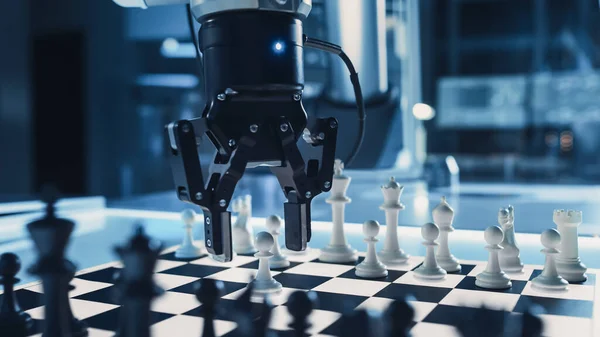 Κοντινό πλάνο μιας Τεχνητής Νοημοσύνης που χειρίζεται ένα φουτουριστικό ρομποτικό βραχίονα σε ένα παιχνίδι σκάκι ενάντια σε έναν άνθρωπο. Το ρομπότ μετακινεί ένα πιόνι. Βρίσκονται σε ένα Εργαστήριο Σύγχρονης Έρευνας Υψηλής Τεχνολογίας. — Φωτογραφία Αρχείου