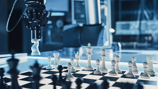 Close Up Shot of a Artificial Intelligence Operating a Futuristic Robotic Arm in a Game of Chess Against a Human. Robot Moves a Knight. They are in a High Tech Modern Research Laboratory.