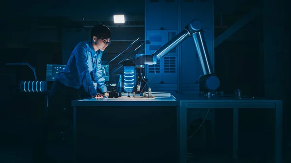 Japansk udviklingsingeniør tester en kunstig intelligens grænseflade ved at spille skak med en futuristisk robotarm. De er i en High Tech Modern Research Laboratory med lav nøgle lys. - Stock-foto