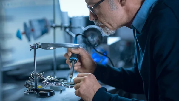 Portrait de l'ingénieur du Moyen Âge focalisé dans les lunettes travaillant avec un équipement laser de haute précision, utilisant des lentilles et testant l'optique pour la précision requise Électronique — Photo