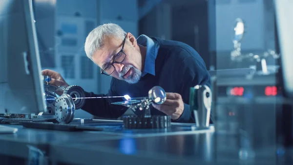 Ritratto di ingegnere di mezza età focalizzato in occhiali che lavora con apparecchiature laser ad alta precisione, utilizzando lenti e ottiche di prova per l'elettronica necessaria precisione — Foto Stock
