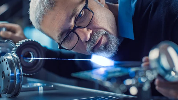 Retrato de cerca del ingeniero de mediana edad enfocado en gafas que trabajan con equipos láser de alta precisión, utilizando lentes y óptica para una electrónica de precisión. Material del superconductor de prueba —  Fotos de Stock