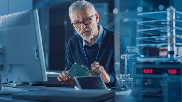 Electronics Maintenance Engineer Soldering Motherboard, Microchip and Circuit Board, Looking through Magnifying Glass, Consults Personal Computer. Ремонт і випробування електроніки — стокове фото