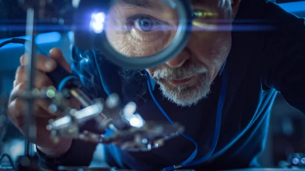 Ingeniero de Mantenimiento y Reparación de Electrónica Soldadora Placa base, Microchip y Placa de Circuito, Mirando a través de Lupa. Tiro conceptual: Primer plano bajo ángulo lupa ojo y cara —  Fotos de Stock